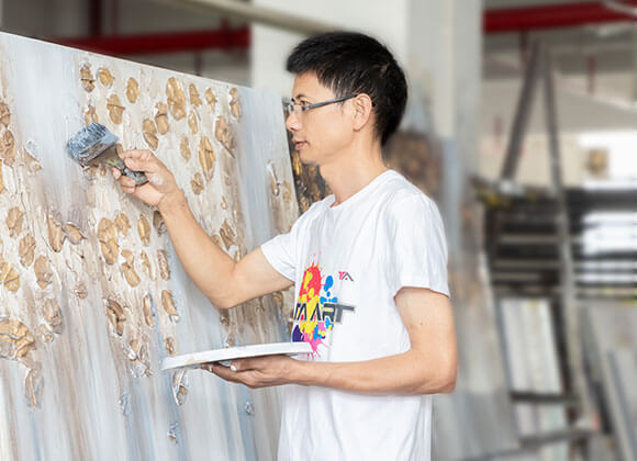 An artist is doing painting on the canvas.